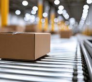 Cardboard box on a metal roller conveyor belt in a warehouse