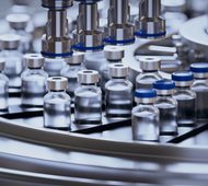 3d render, conveyor with the glass jars, modern pharmaceutical factory. Closeup of ampules are being filled with vaccine and closed with blue caps. Medical wallpaper